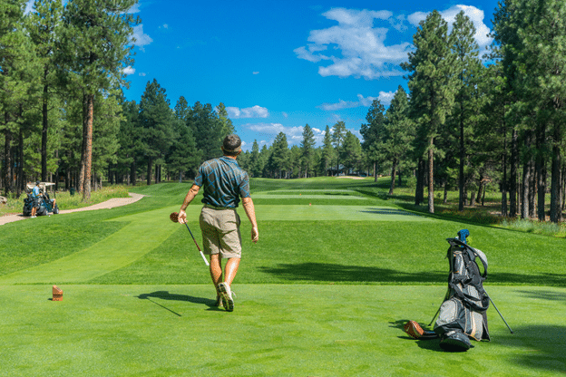 a golfer is laying in a golf course and a golf cart and golf bag in the picture