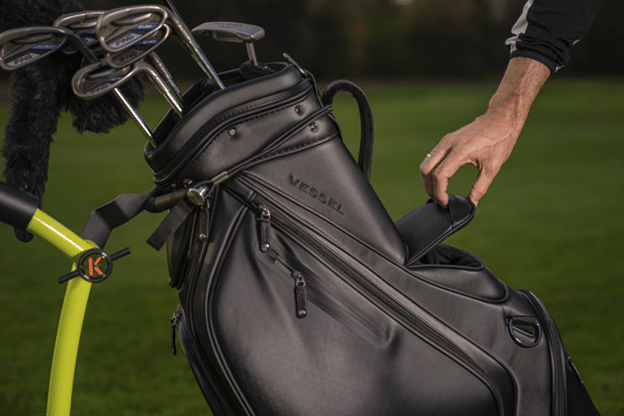 black golf bags with golf accessories in golf course