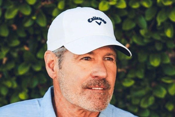 a man is wearing white callaway heritage golf cap